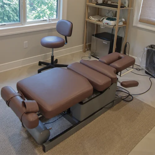Chiropractic adjustment table in a treatment room at East Hills Chiropractic in Roslyn Heights, NY.